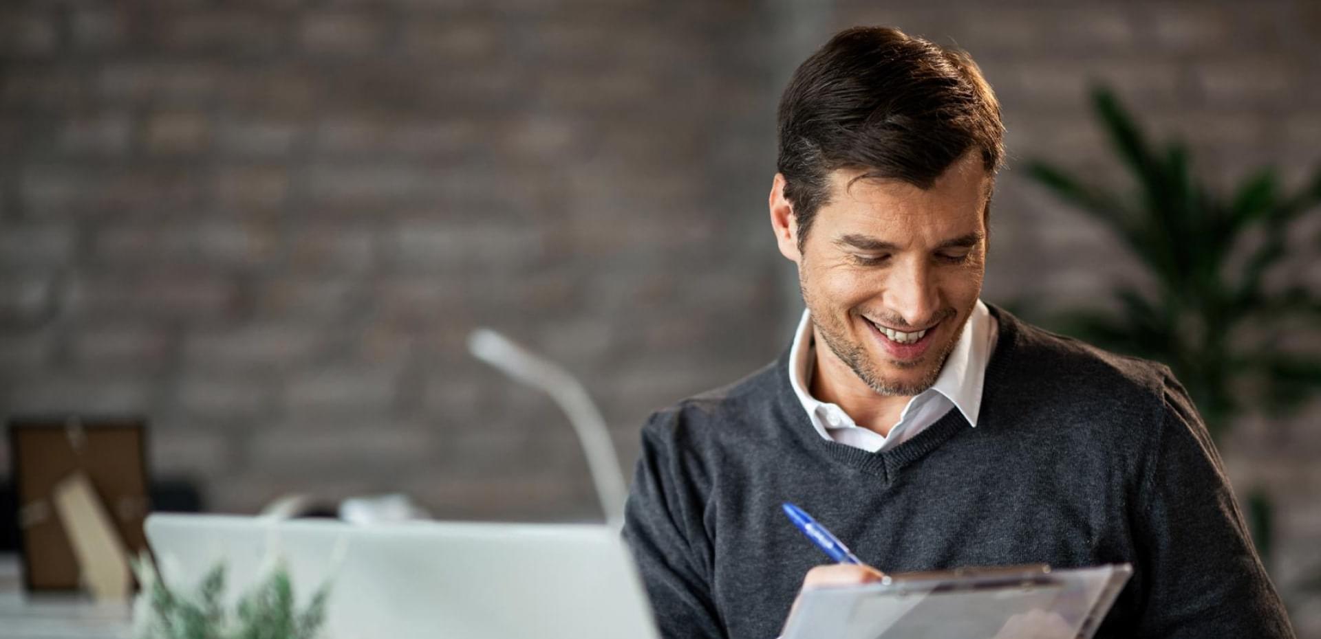 Smiling professional man reviewing documents in a modern office setting